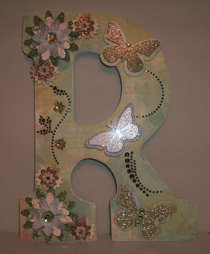 a decorative letter decorated with flowers and butterflies