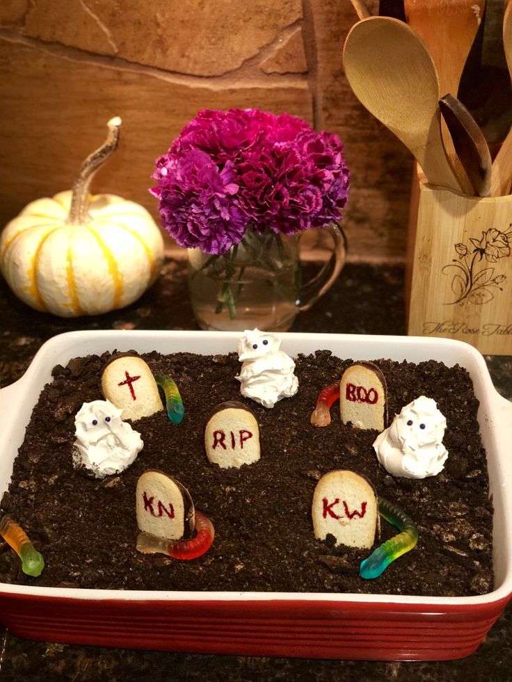 a cake decorated to look like tombstones in the dirt with candles and candy on top