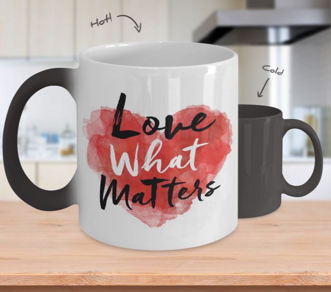 two coffee mugs with the words love what matters written on them, sitting on a kitchen counter