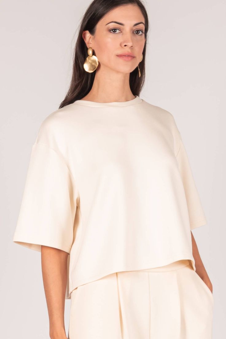 Slide into our buttery soft Avery Overlap Top. Crafted with premium scuba modal fabric, this top offers superior comfort and luxurious texture. The unique overlap back detail adds a touch of sophistication, while the 3/4 sleeves and round neck create an elegant silhouette. Perfect for any occasion, this top is cropped for a stylish and contemporary look. Effortless Beige Tops For Loungewear, Chic Cream Tops For Layering, Chic Cream Top For Layering, Relaxed Beige Top For Layering, Cream Summer Loungewear Tops, Everyday Solid Color Modal Tops, Chic Cotton Tops For Loungewear, Cream Relaxed Fit Top For Loungewear, Chic Crew Neck Top For Loungewear