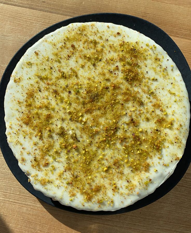 a pizza sitting on top of a pan covered in cheese and seasoning next to a knife