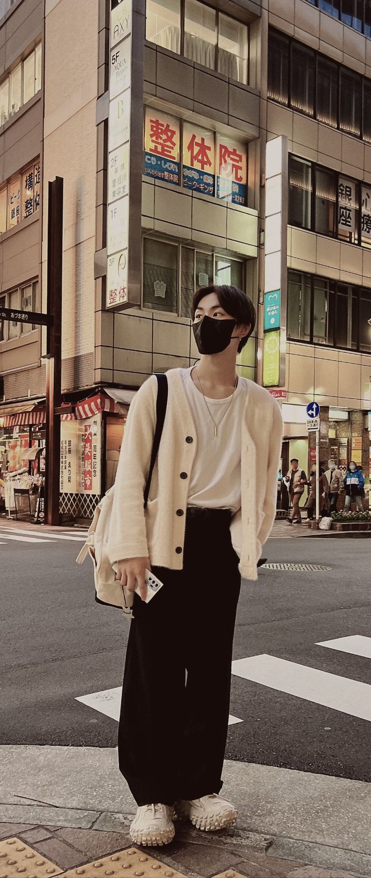 a man wearing a face mask standing on the street