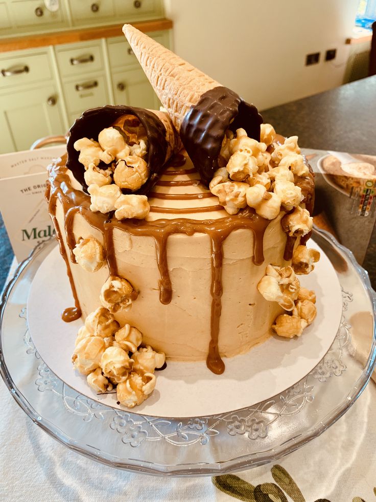 there is a cake that has chocolate and popcorn on the top with ice cream drizzle