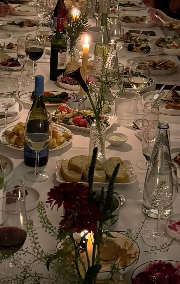 a long table is set with plates and wine glasses for an elegant dinner or party