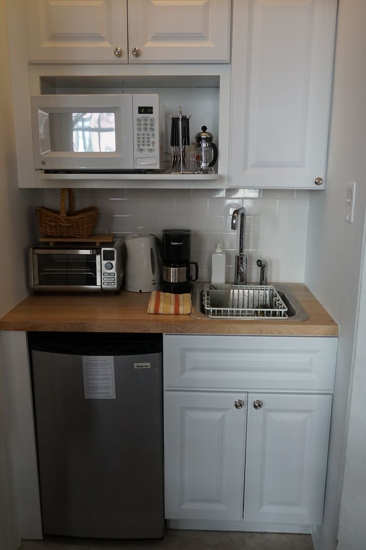 a small kitchen with white cabinets and stainless steel appliances, including a dishwasher