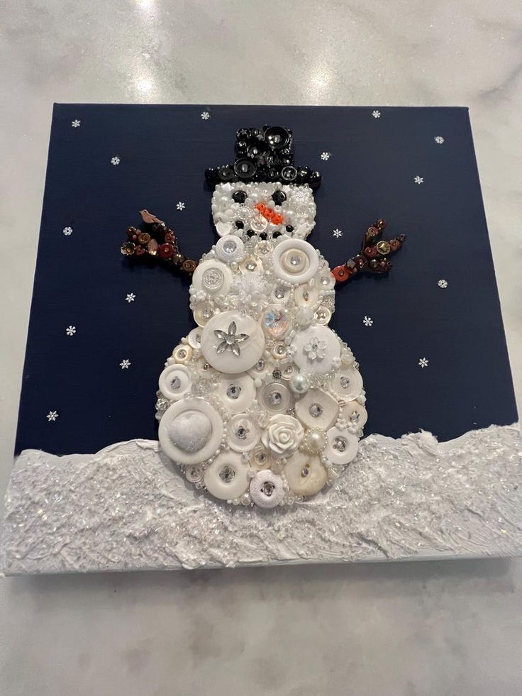 a snowman made out of buttons on a card