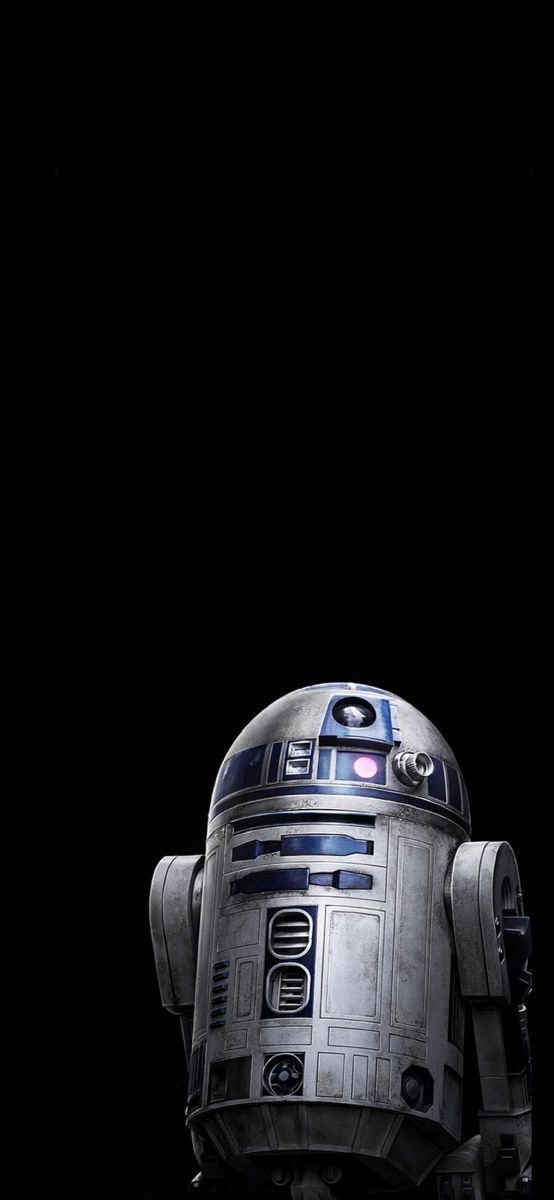 a star wars r2d2 robot is standing in the dark