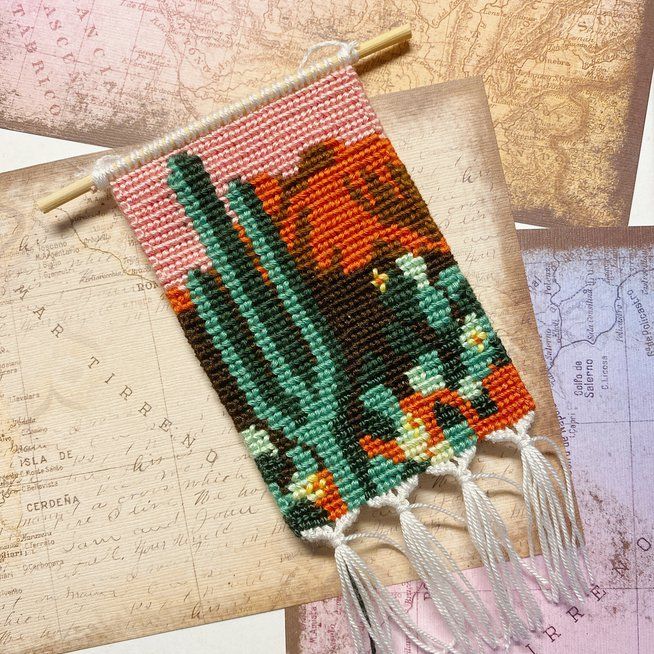 a cross stitch project with flowers and tassels on top of an old map