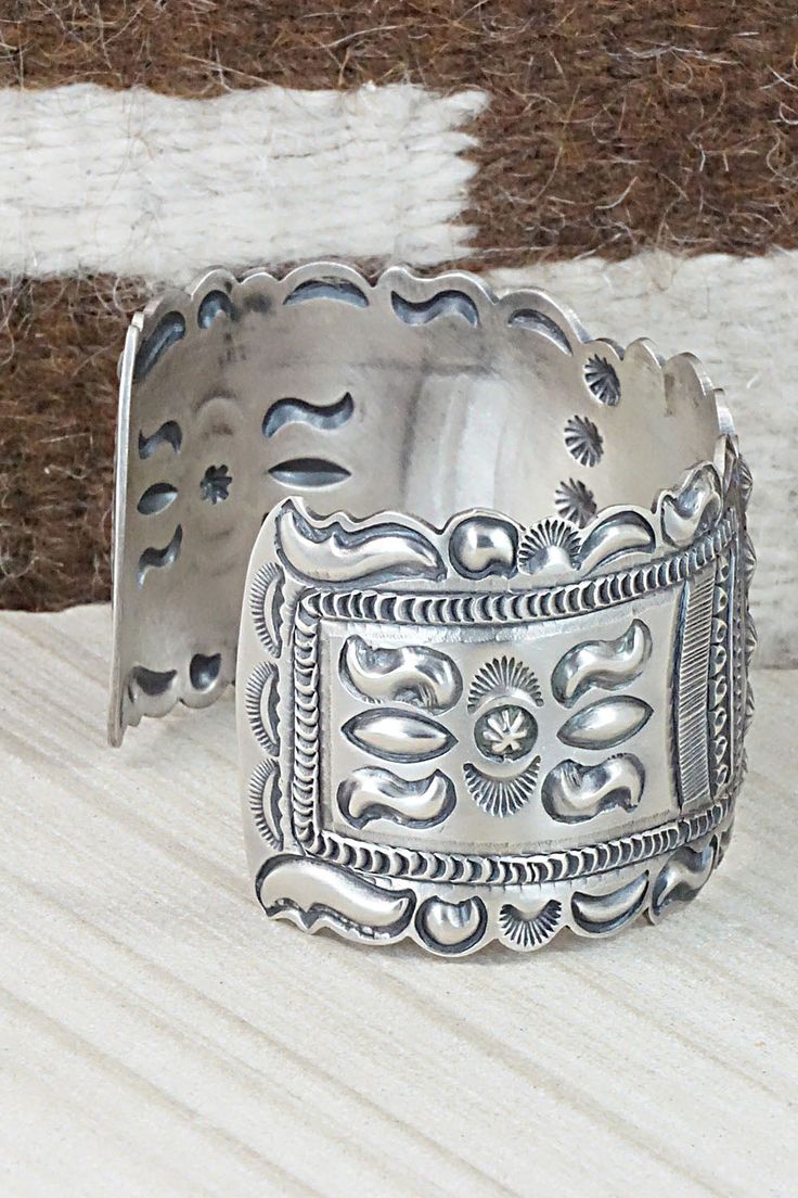 This sterling silver bracelet was made by Navajo silversmith Eugene Charley. The inside is signed and stamped sterling.Size: 5 3/4" (will fit up to a 7" wrist)Gap: 1 1/4"Width: 1 1/2"Free shipping on all orders! We ship with USPS and always include tracking. All orders ship within a day of payment.Returns are accepted up to 30 days after you receive your order. Just send us a message. Our shop offers cash back or store credit. The item must be returned in new condition. Artisan Silver Bracelet With Stamped Details, Artisan Sterling Silver Bracelet With Etched Details, Artisan Sterling Silver Concho Cuff Bracelet, Western Sterling Silver Cuff Bracelet With Concho, Southwestern Stamped 925 Cuff Bangle Bracelet, Artisan Silver Concho Cuff Bracelet, Unique Stamped Sterling Silver Collectible Bracelet, Western Sterling Silver Cuff Bracelet Gift, Western Silver Cuff Bracelet With Concho