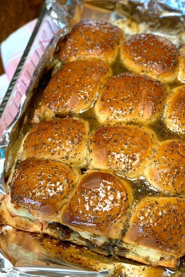 hot dog buns covered in brown sauce and sprinkled with sesame seeds