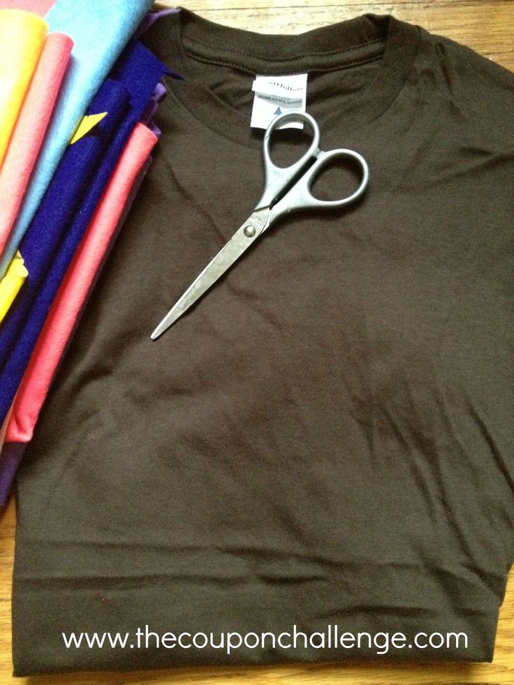 a pair of scissors sitting on top of a t - shirt next to folded fabric