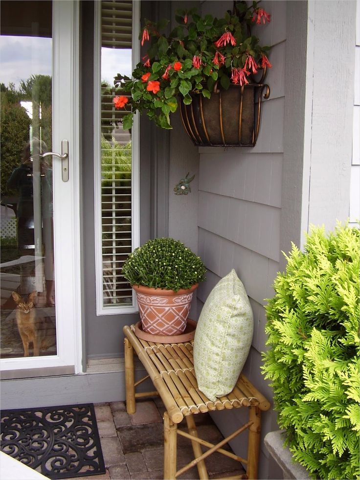 two potted plants are sitting on a small bench in front of a door way