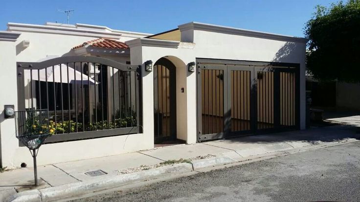 a white house with an iron gate on the front