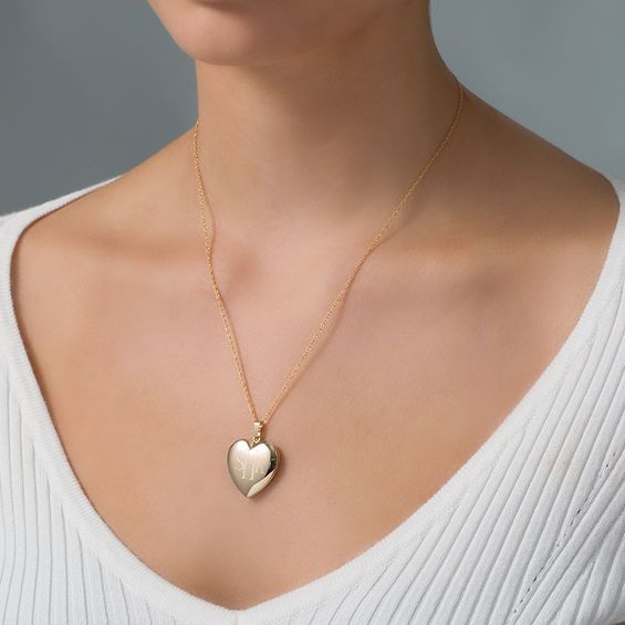 She’ll treasure the sweet design of this lovely personalized heart locket. Fashioned in 14K gold fill, this precious heart-shaped look showcases the three initials of your choice inscribed in a classic print font. This hinged style opens to reveal space for two small photos or other mementos. Please enter initials from left to right in the order you would like them to appear. The center initial will be larger as shown. Buffed to a brilliant luster, this locket suspends along an 18.0-inch rope chain that secures with a spring-ring clasp. Personalized Heirloom Heart Jewelry, Heirloom Personalized Heart Jewelry, Elegant Personalized Double Heart Locket Necklace, Gold Heart Cut Locket Necklace For Keepsake, Elegant Initials Locket Necklace For Anniversary, Elegant Yellow Gold Heart Pendant Locket Necklace, Elegant Anniversary Locket Necklace With Initials, Engraved Yellow Gold Heart Necklace For Wedding, Elegant Personalized Medallion Heart Necklace