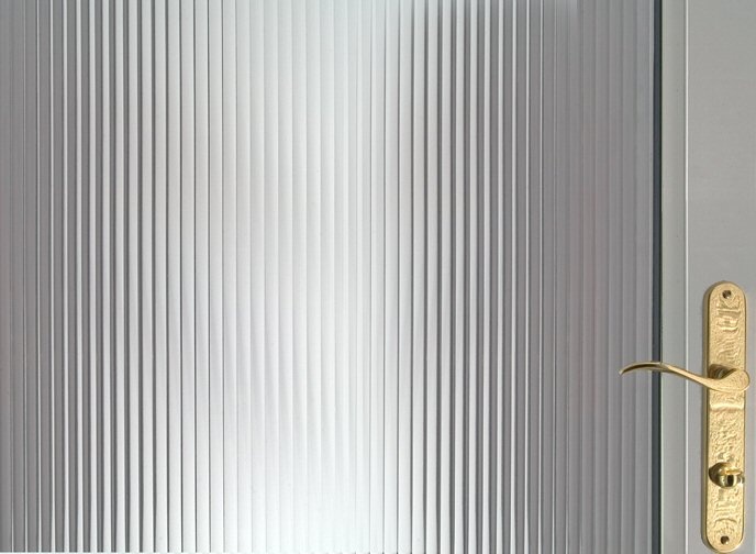 a close up of a metal door handle on a glass door with vertical blinds in the background