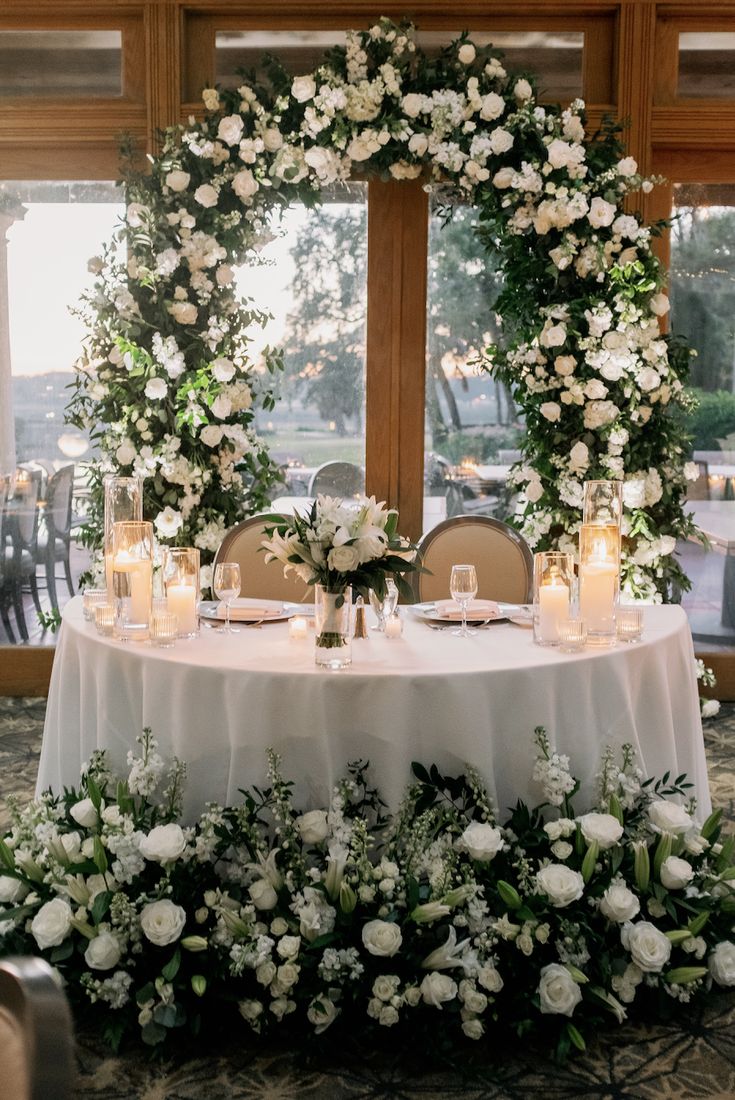 a table with white flowers and candles on it