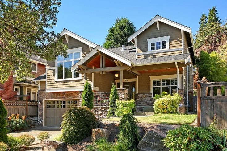 a large house with lots of trees and bushes around it's front entrance, surrounded by greenery