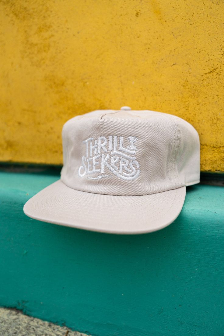 Thrill Seekers Coaster Cap Bone Cream Casual Hat With Flat Bill, Casual Cream Flat Bill Hat, Beige Trucker Hat Snapback, Beige Adjustable Trucker Hat For Streetwear, Casual Beige Flat Bill Hat, Cream Cotton Snapback Hat, Cream Adjustable Flat Bill Trucker Hat, Beige Baseball Cap For Streetwear, Beige 5-panel Hats For Spring