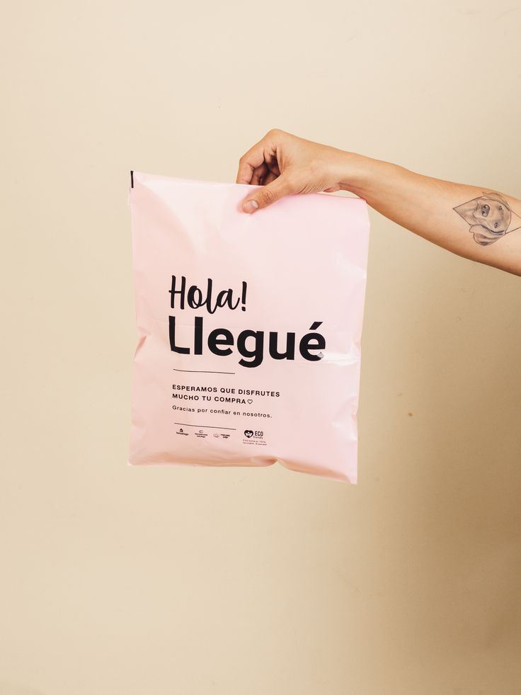 a person holding up a pink bag with the word hola league written on it