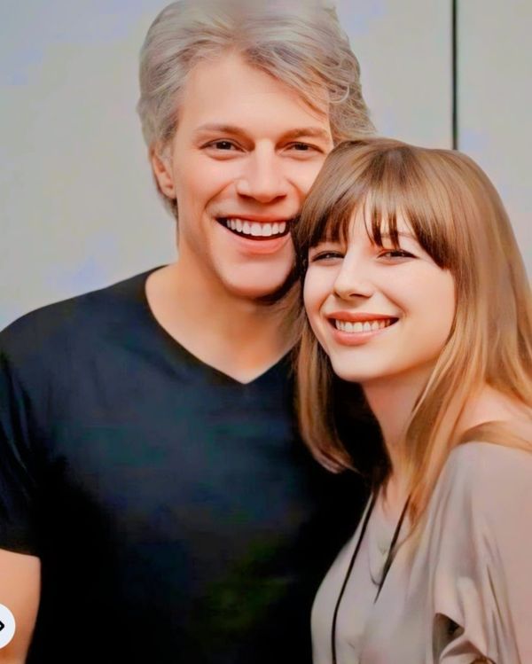 an older man and young woman smiling for the camera with their arms around each other