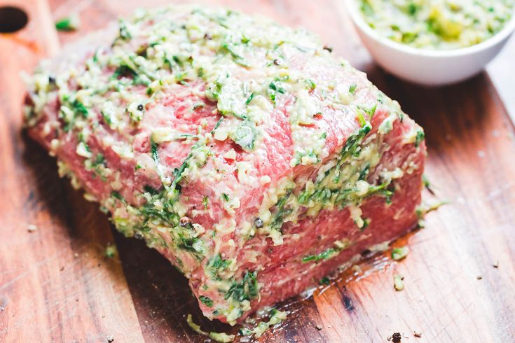 a piece of meat sitting on top of a wooden cutting board