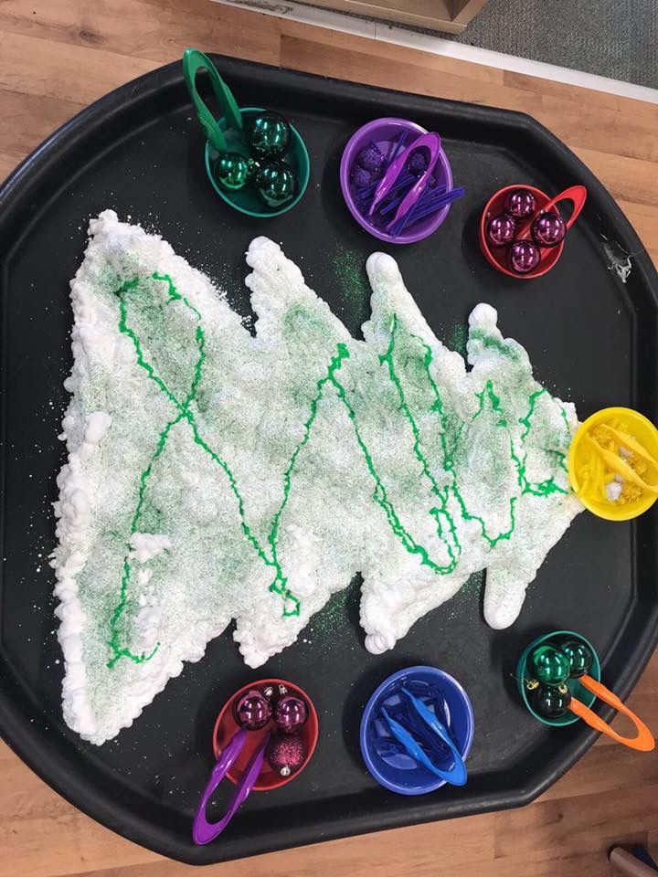 a black tray topped with lots of white frosting and colorful plastic utensils