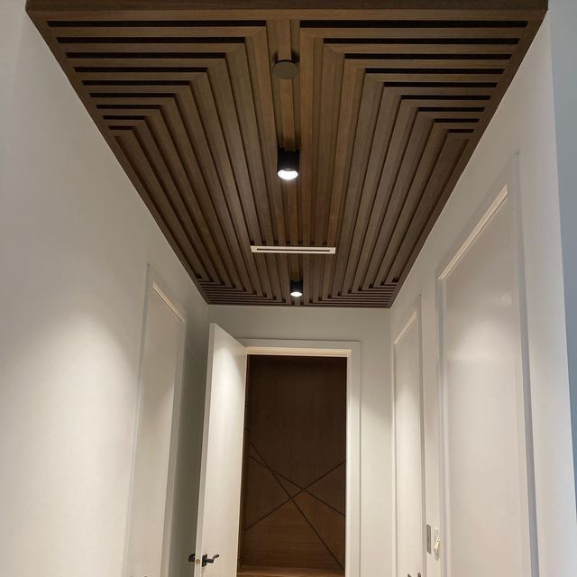 an empty hallway with white walls and wooden ceiling