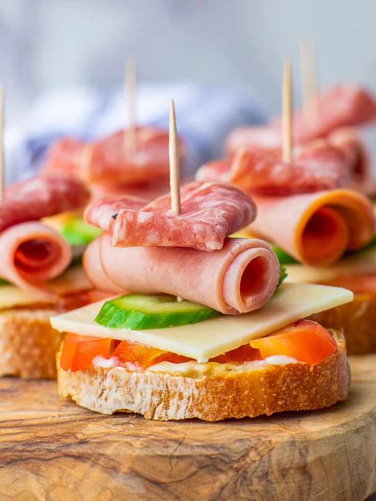 ham and cheese sandwich with toothpicks on a wooden cutting board, ready to be served