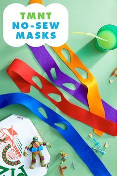 colorful paper cutouts and scissors on a green surface