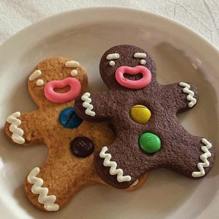 two decorated cookies sitting on top of a white plate