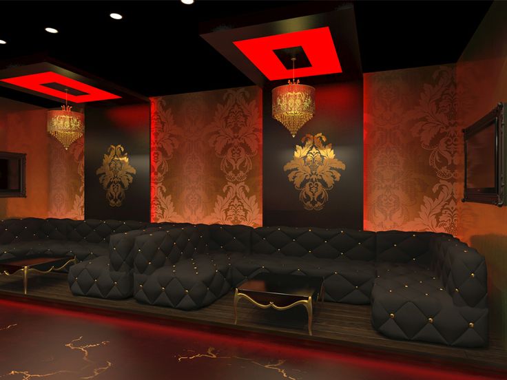 a room with couches and chandeliers on the walls, in front of red lighting