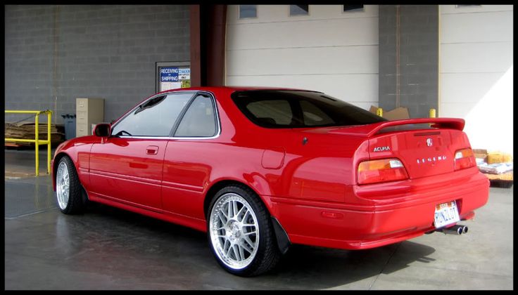 a red car parked in front of a garage