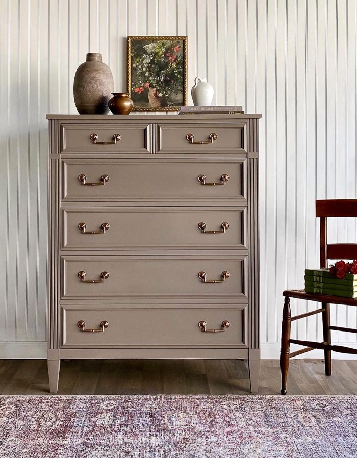 an old dresser with many drawers and vases on top