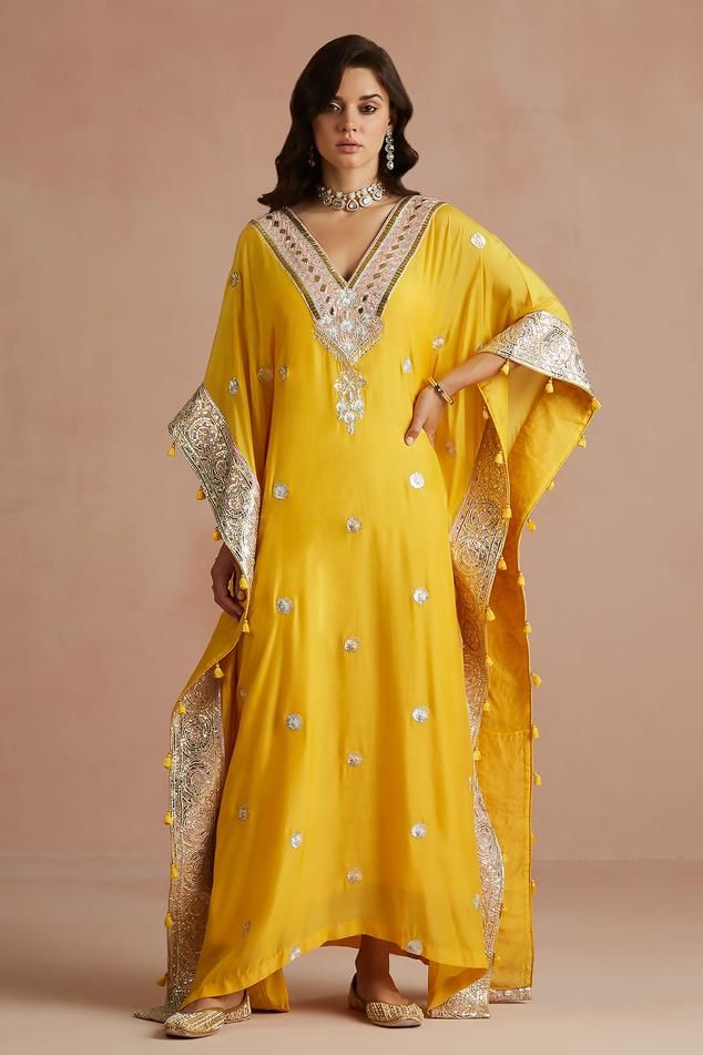 Yellow kaftan with floral gota embroidery and tassel detailing. Paired with slip.
Components: 2
Pattern: Embroidered
Type Of Work: Floral
Neckline: V neck
Sleeve Type: Kaftan sleeves
Fabric: Kaftan: Pure Muslin, Slip: Shantoon
Color: Yellow
Other Details: 
Kaftan sleeves
Tassels detailing
Length:
Kaftan: 54 inches
Slip: 48 inches
Occasion: Puja - Aza Fashions Kaftan With Tassels, Sureena Chowdhri, Yellow Kaftan, Kaftan Sleeves, Gota Embroidery, Kaftan Pattern, Kaftan For Women, Kaftan Designs, Kaftan Style