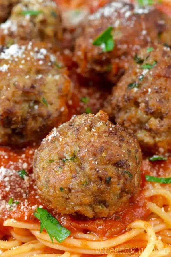 spaghetti and meatballs with parmesan cheese on top