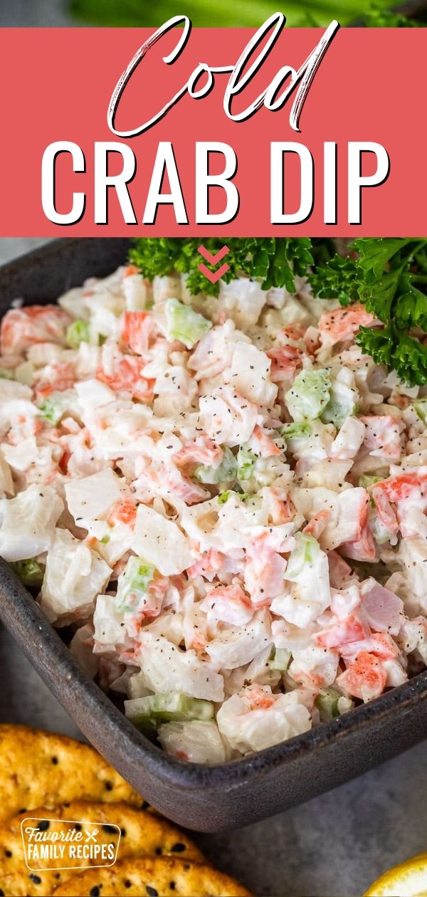 a bowl filled with crab dip next to crackers