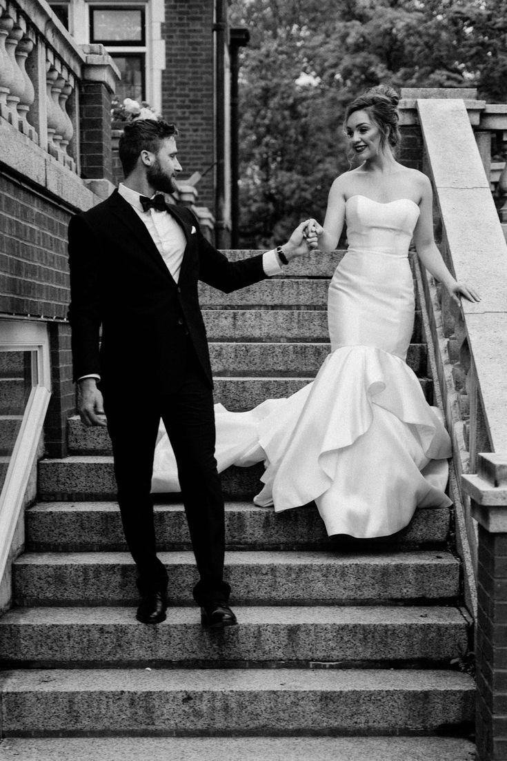 a bride and groom are walking down the stairs