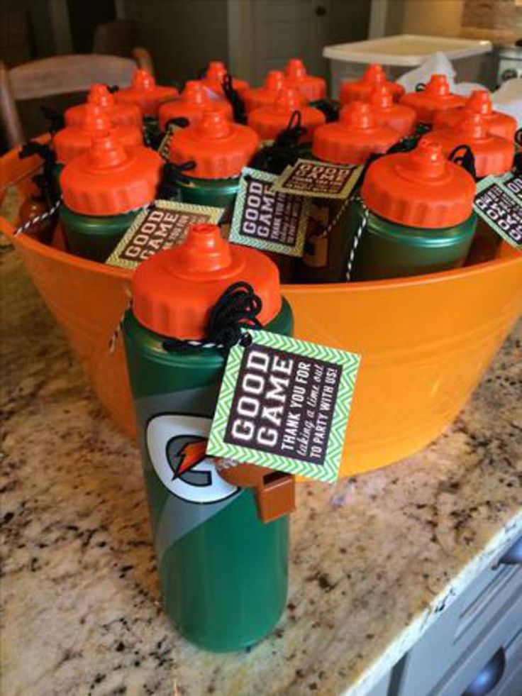 orange and green sports water bottles in a bowl on a kitchen counter with tags attached to them