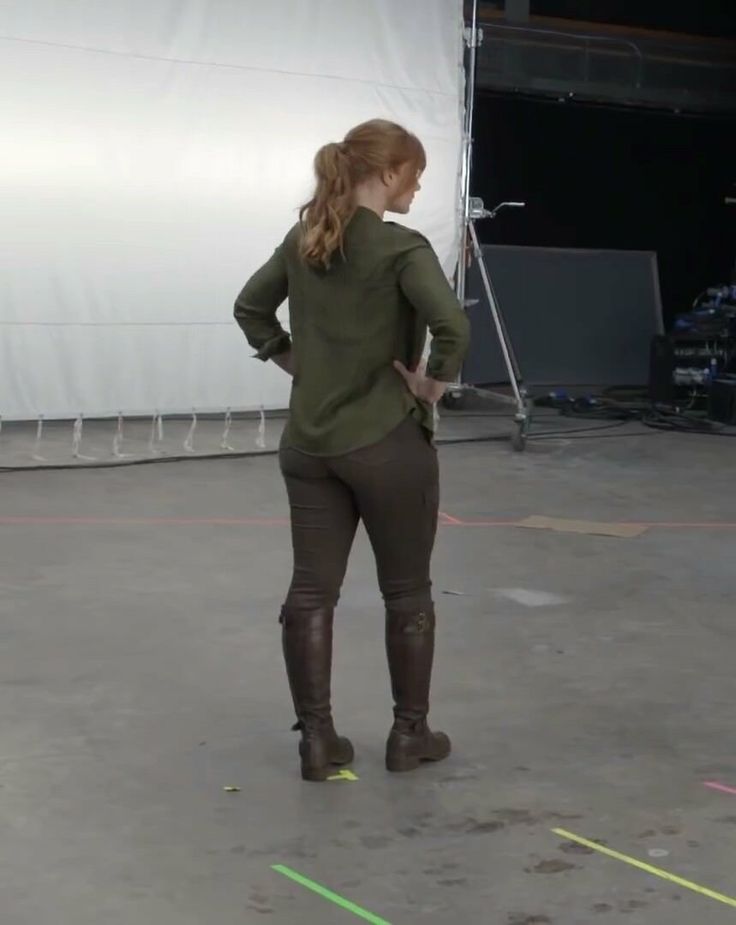 a woman standing in front of a white screen with her back turned to the camera