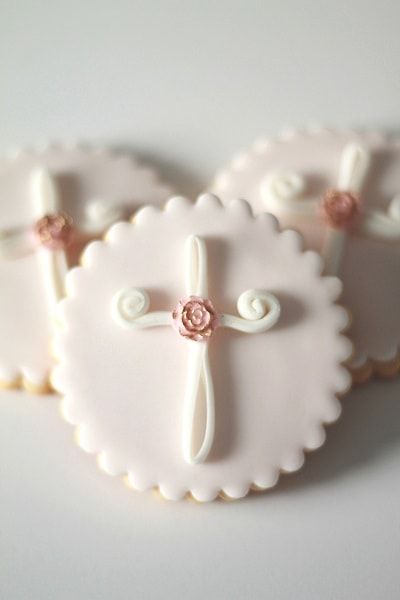 three cookies decorated with white and pink icing