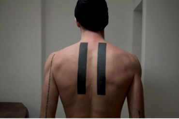 the back of a man's neck with two black strips on it