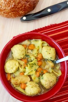 a red bowl filled with dumplings and vegetables