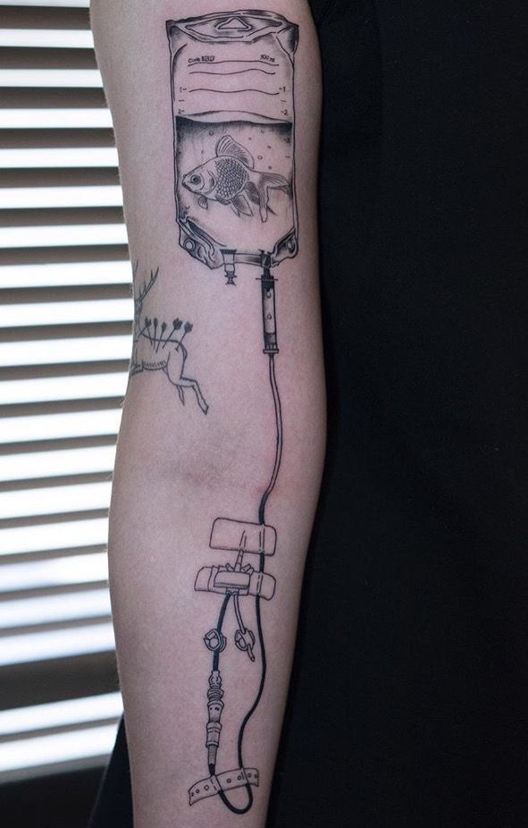 a person with a tattoo on their arm has a fish in a tank attached to it