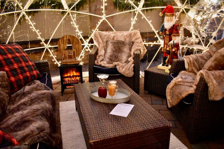 a living room filled with lots of furniture and christmas lights on the wall behind it