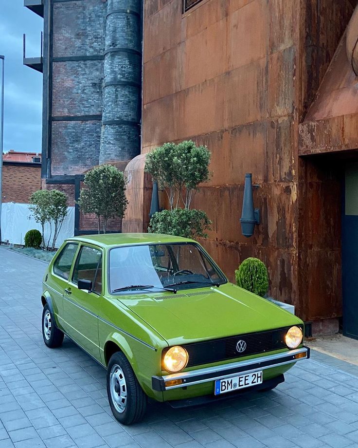 a green car parked in front of a building