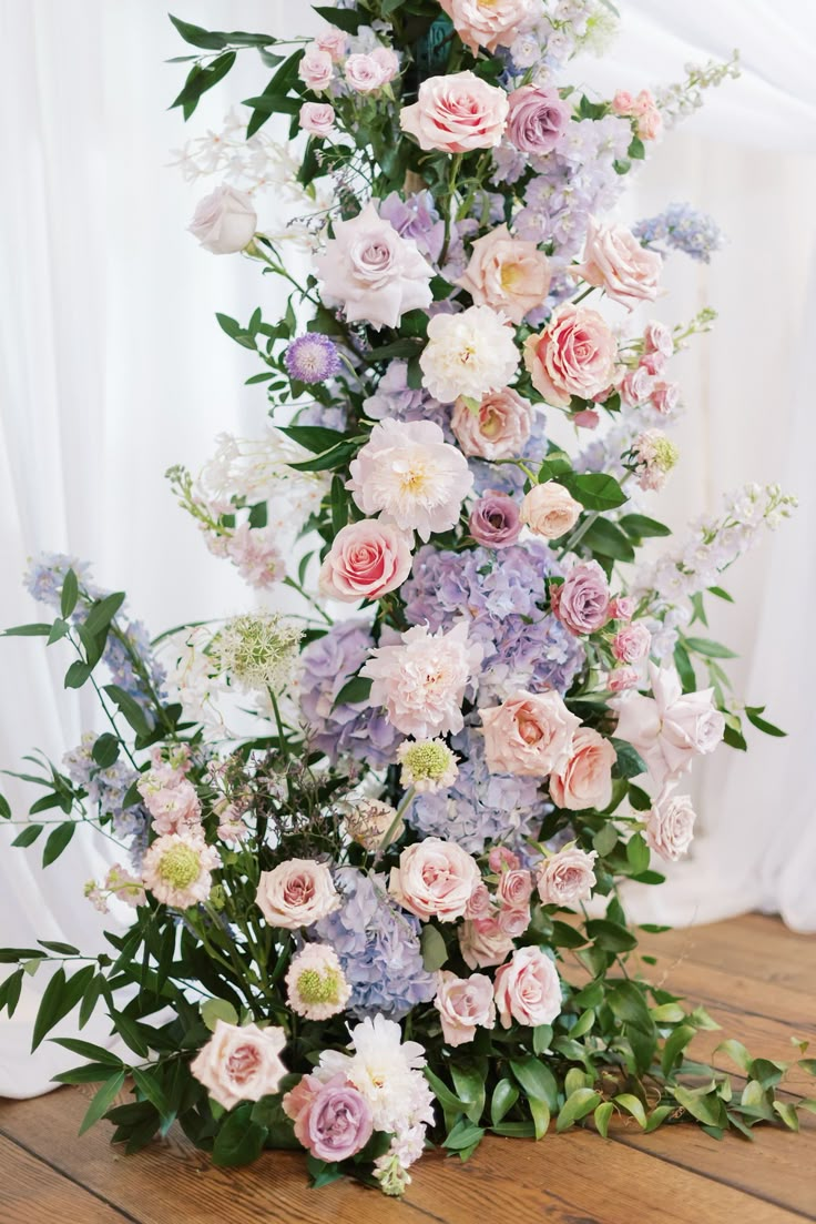 an arrangement of flowers on a wooden floor