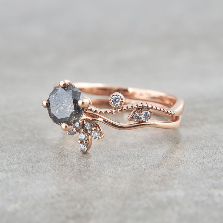 a close up of a ring with diamonds on the bottom and an oval shaped black diamond in the middle