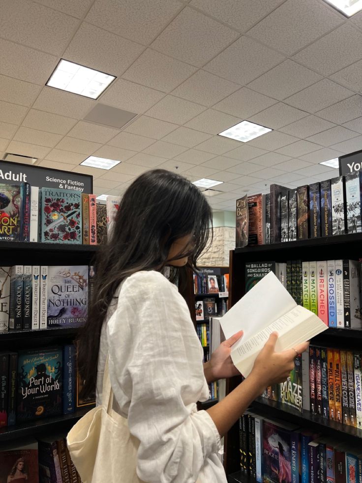 a woman reading a book in a library