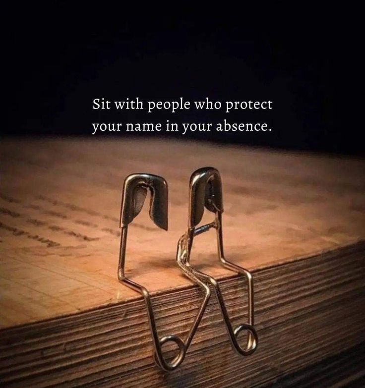 there is a pair of metal scissors on the floor with a quote about people who protect your name in your presence