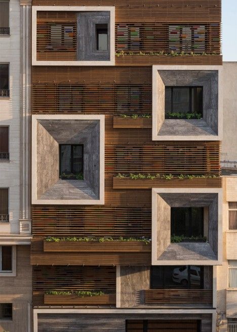 the facade of an apartment building with wooden slats on it's sides and windows